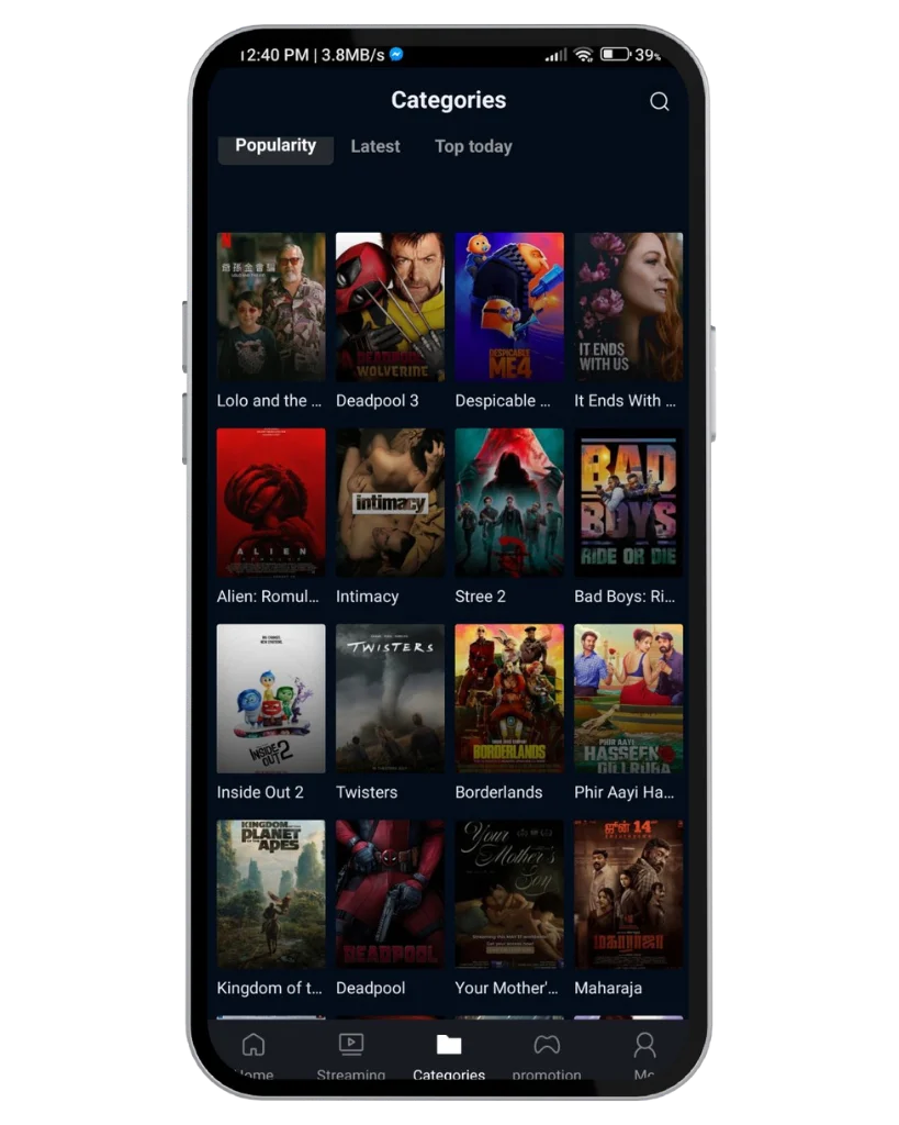 A imagem mostra a tela de um smartphone exibindo a seção "Categorias" de um aplicativo de streaming ou mídia. A interface possui abas rotuladas como *"Popularidade", *"Mais recentes"* e *"Mais vistos hoje"*, com "Popularidade" atualmente selecionada. Abaixo dessas abas, diversos títulos de filmes e séries são exibidos em um layout de grade, cada um representado por um pôster em miniatura. Entre os títulos estão *Deadpool 3, Meu Malvado Favorito 4, Divertida Mente 2, Alien: Romulus e outros. Na parte inferior da tela, há uma barra de navegação com ícones para diferentes seções, como *Início, **Streaming, **Categorias, **Promoção* e *Perfil*.